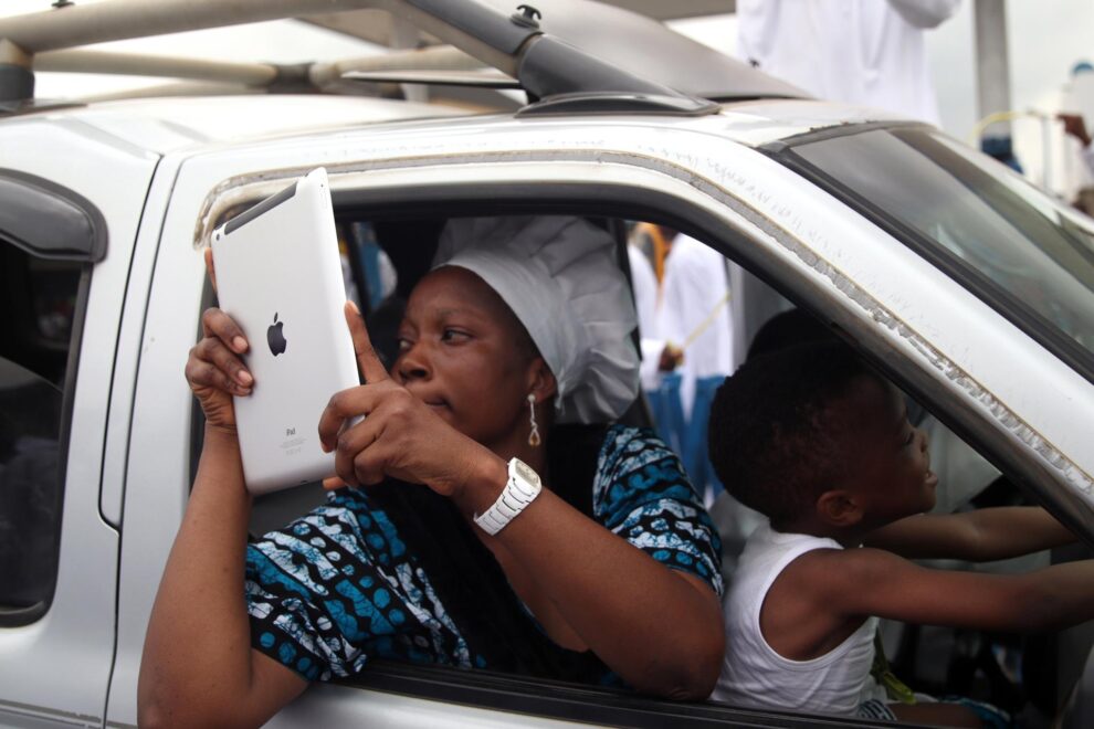 Una feligresa toma fotografías en la procesión del Domingo de Ramos en Lagos.