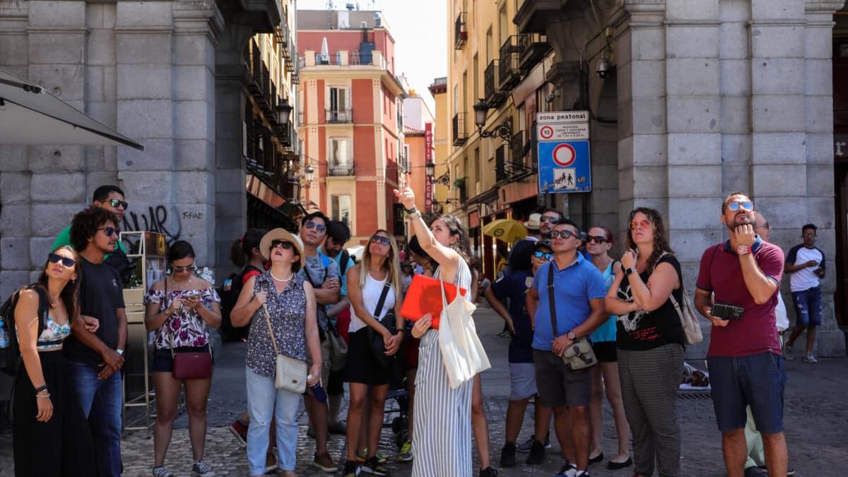 Varios turistas se fotografían en una de las calles cercanas a la Plaza Mayor de Madrid.