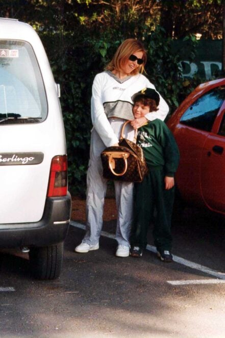 Aless, cuando era un niño, en los brazos de su madre