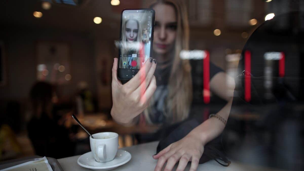 Rosa, conocida como Ghoulbabyghoul en la app Tik Tok donde cuenta con más de 3000 seguidores, se graba con su teléfono móvil en una cafetería, en Madrid