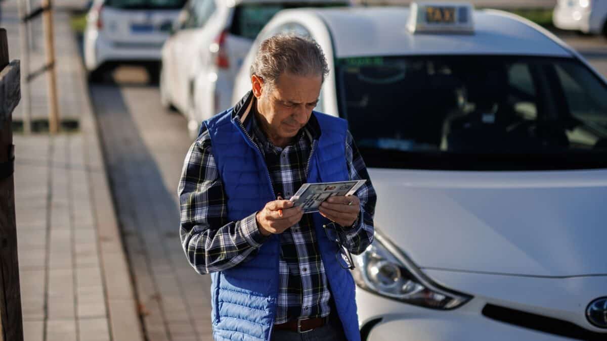 Un taxista delante de su coche en Madrid.