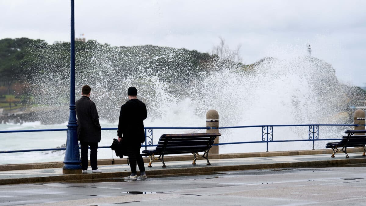 Dos personas observan el oleaje en el puerto de Santander