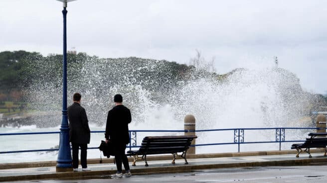 Dos personas observan el oleaje en el puerto de Santander
