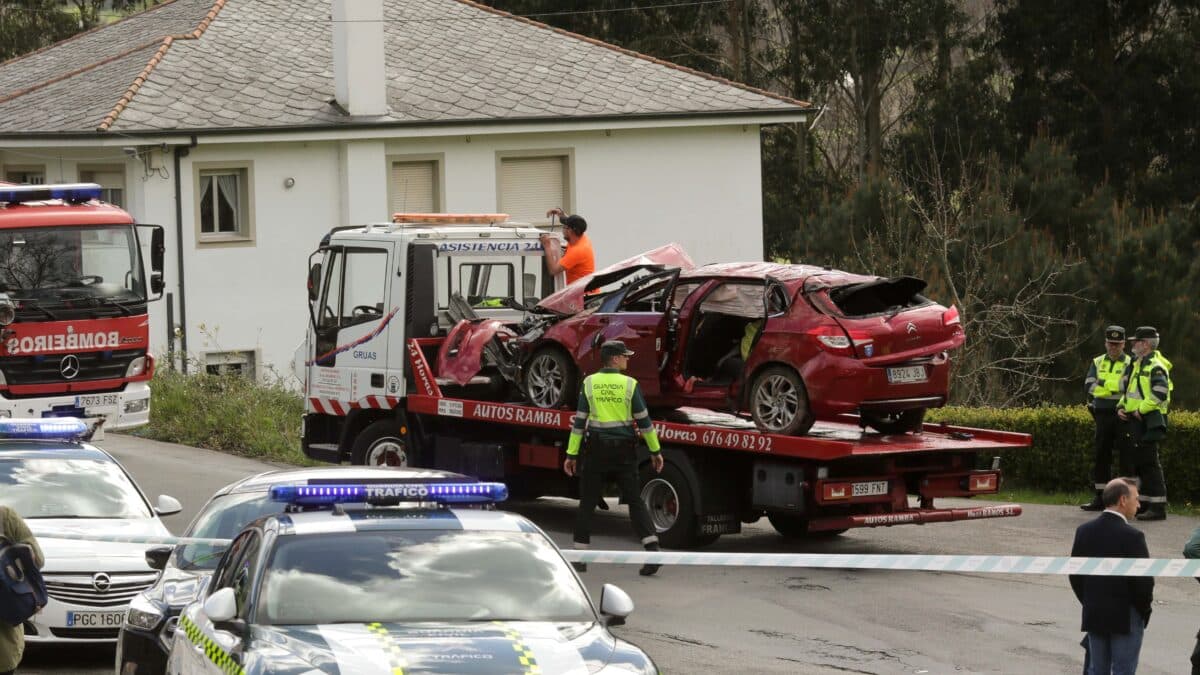 Un Guardia Civil vigila la retirada del coche siniestrado, en el accidente, por una grúa, a 1 de abril de 2023