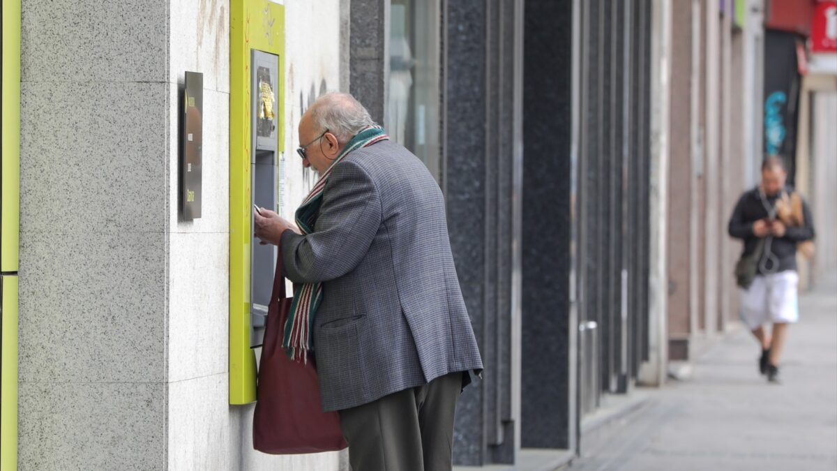 Un anciano saca dinero de un cajero en Madrid.