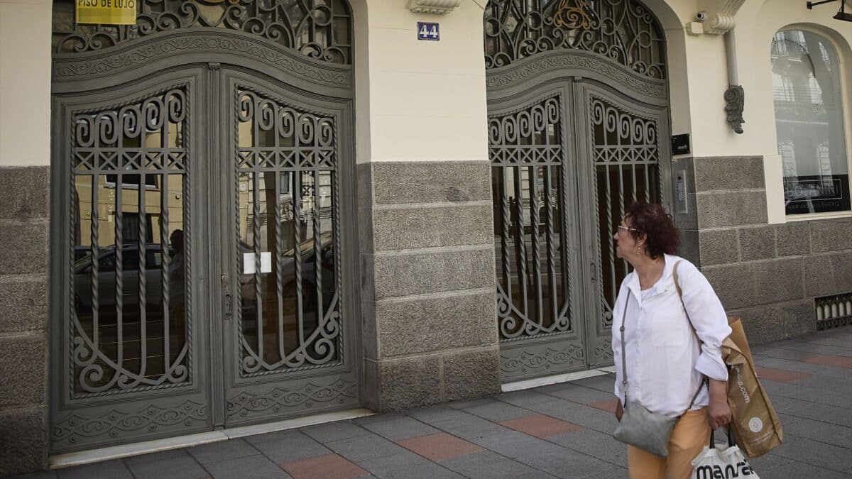 Una mujer observa el anuncio de una vivienda de lujo en venta en el barrio de Almagro, en Madrid.