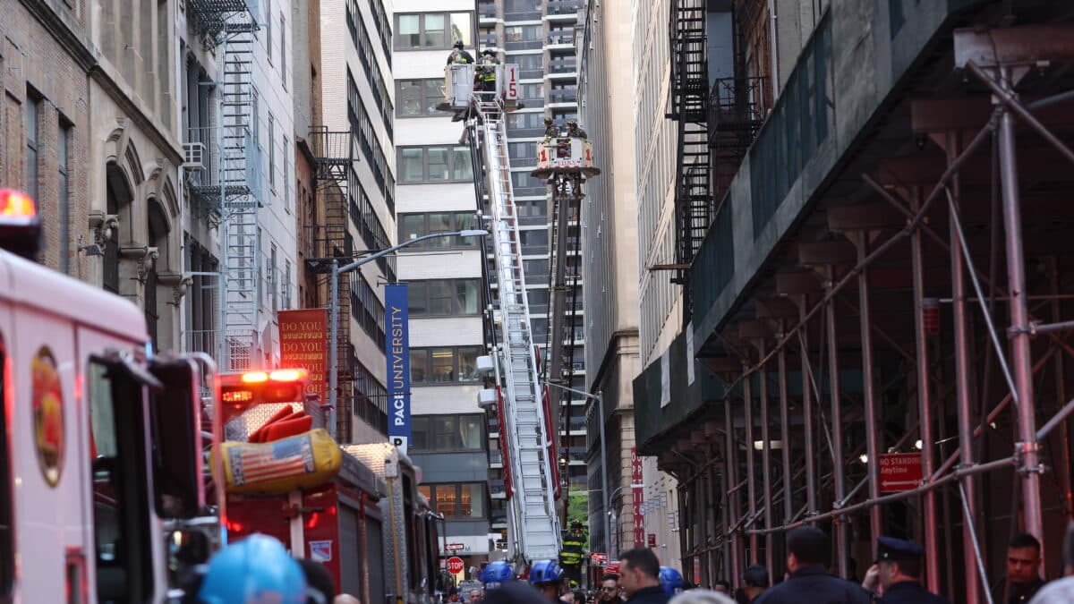- Bomberos del Departamento de Bomberos de la ciudad de Nueva York trabajan en camiones escalera en el lugar del derrumbe de una estructura de estacionamiento en el distrito financiero de la ciudad de Nueva York