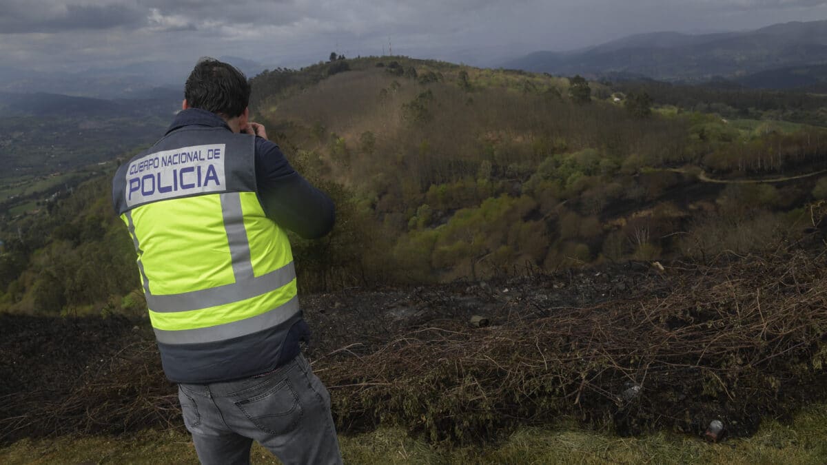 Un miembro de la Policía Científica filma la zona arrasada por el fuego en la cima del Monte Naranco, este sábado.