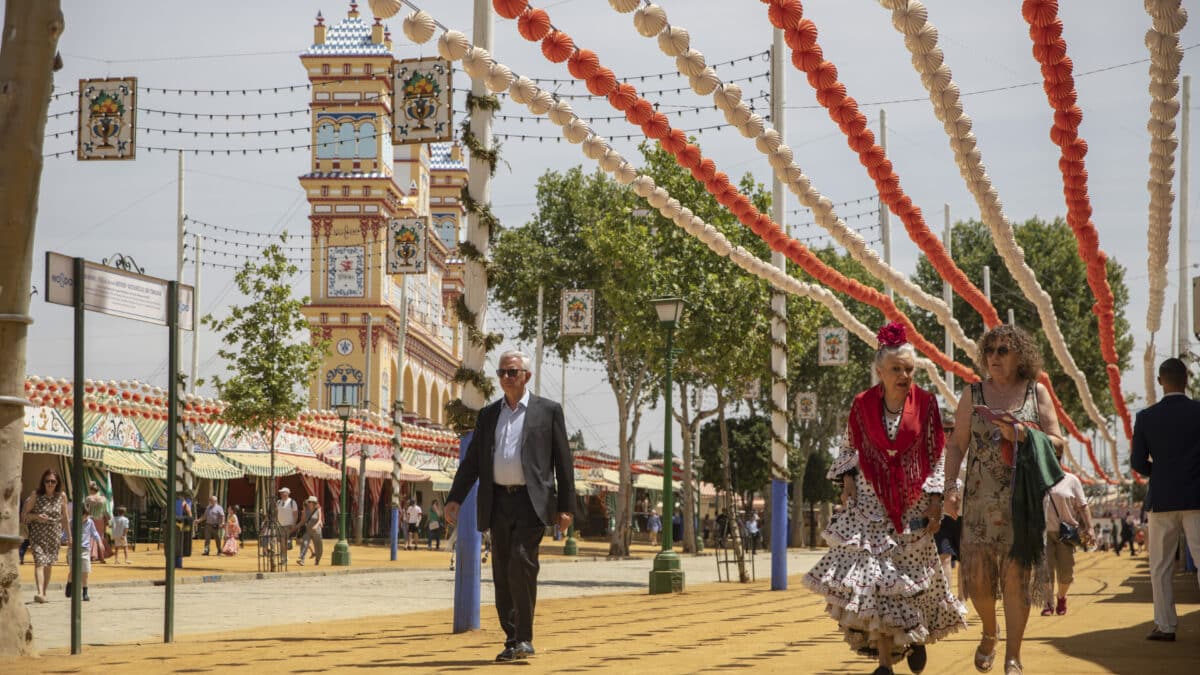 Varias personas caminan por el Real en la feria.