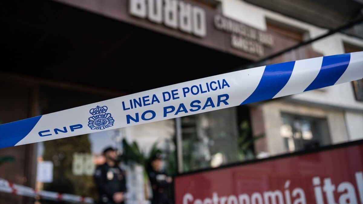 Agentes de la Policía Científica en la entrada del restaurante italiano quemado este fin de semana en Madrid.