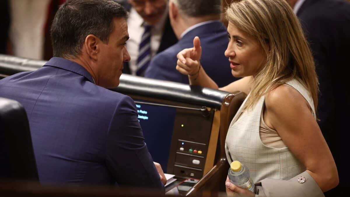 El presidente del Gobierno, Pedro Sánchez, y la ministra de Transportes, Movilidad y Agenda Urbana, Raquel Sánchez, conversan en una sesión plenaria, en el Congreso.