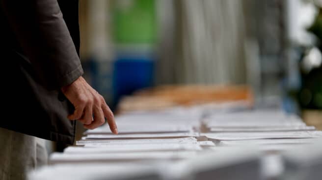 Un hombre observa las papeletas en un colegio electoral de Madrid este domingo durante las elecciones municipales y autonómicas