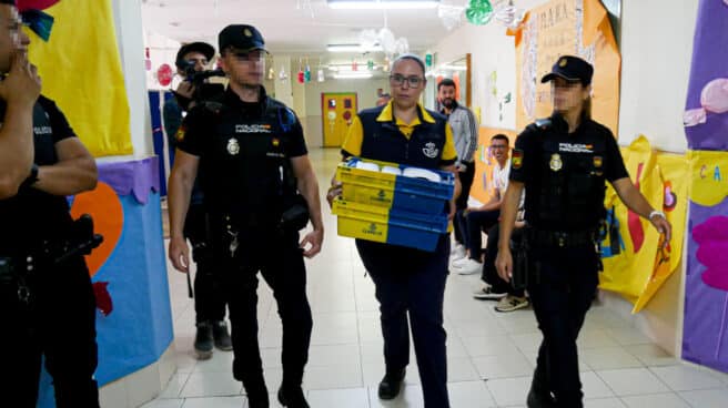 Dispositivo de Seguridad en Colegio León Solá de Melilla en el que varios agentes escoltan a la funcionaria de Correos a la mesa electoral para entregar los votos por correo.