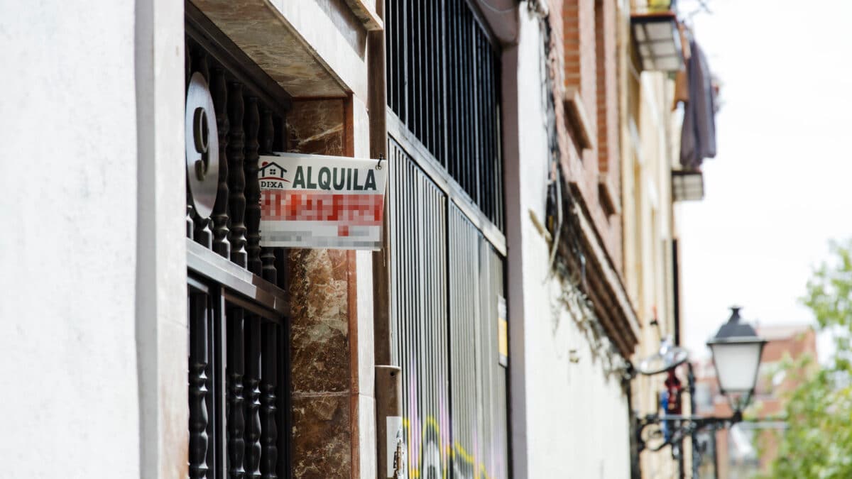 Un cartel de 'Alquila' de una inmobiliaria, en un portal del distrito de Embajadores