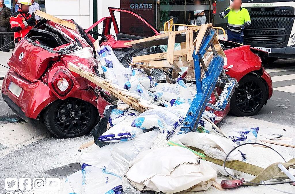 Coche aplastado por un palé que se ha caído de una grúa en un accidente en Granada.