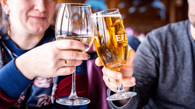 Two people are comparing wine and beer to see which one has more calories.