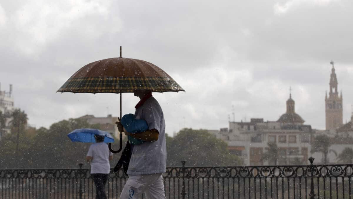 Dos personas caminan bajo sus paraguas el día en que han puesto en aviso amarillo a la Comunidad de Andalucía por tormentas y lluvias.