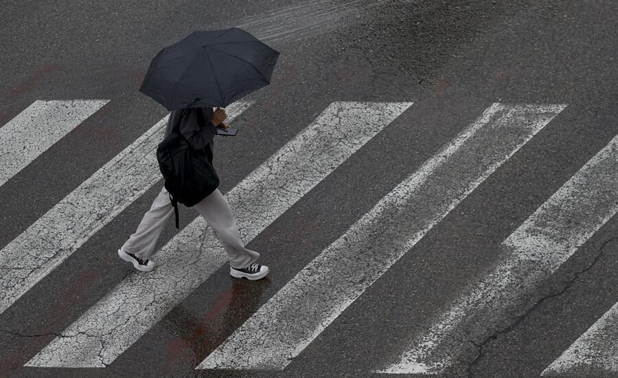 Un persona se protege de la lluvia con un paraguas este lunes en Burjassot (Valencia)