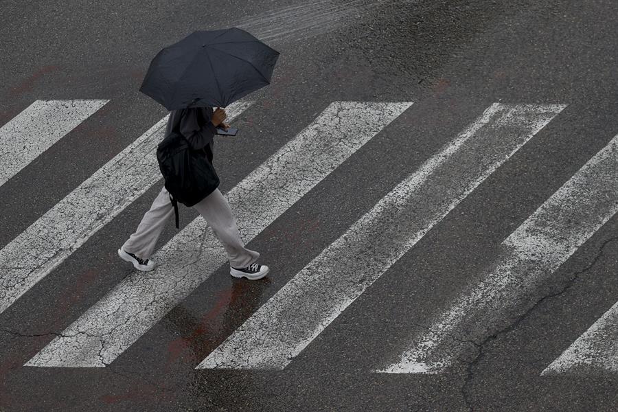 Un persona se protege de la lluvia con un paraguas este lunes en Burjassot (Valencia)