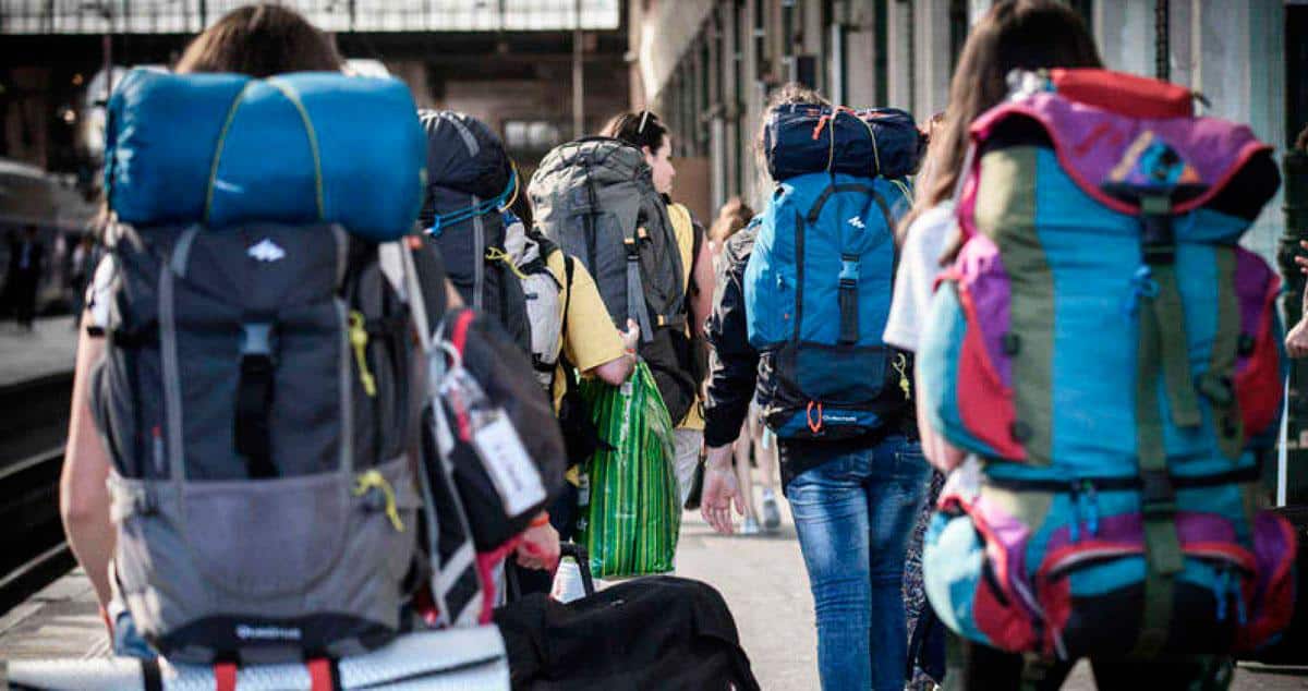 Jóvenes con mochila en una estación.