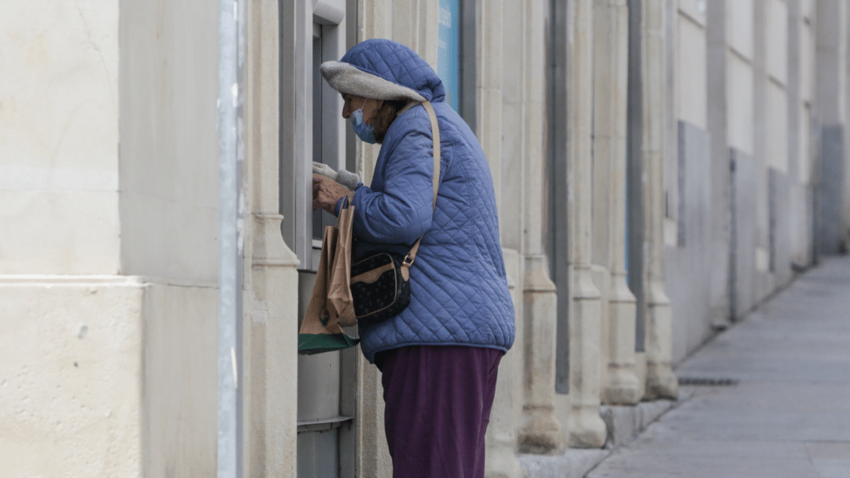 Una mujer cobrando la pensión en un banco.