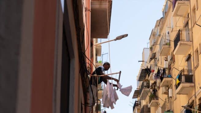 Un hombre tiende la ropa en Barcelona.