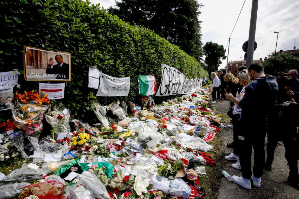 La gente deposita flores y homenajes frente a Villa San Martino, residencia del ex primer ministro italiano Silvio Berlusconi