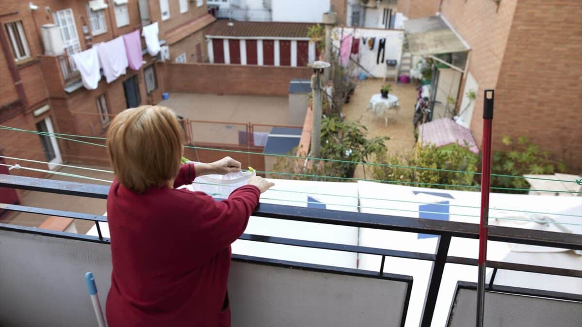 Una anciana tiende ropa en el balcón de su casa de Carabanchel, Madrid.