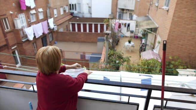 Una anciana tiende ropa en el balcón de su casa de Carabanchel, Madrid.