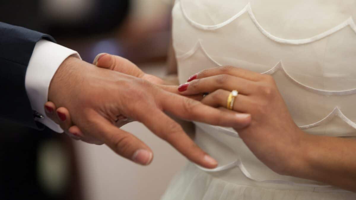 Una pareja se pone sus anillos de boda.