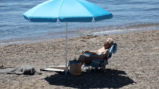 El tiempo en España marcado por el calor extremo en el fin de semana de junio 2023, con una señora tomando el sol en una playa de Málaga