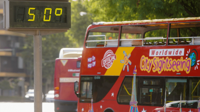 Un autobús delante de un termómetro que marca 5Oº durante la ola de calor de 2022, que podría afectar también a las elecciones generales de 23 de julio de 2023