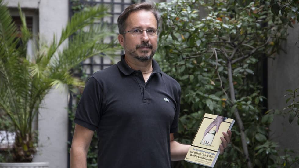 El economista especializado en pensiones José Ignacio Conde-Ruiz, posa con el libro 'La juventud atracada' que ha escrito junto a su hija Carlotta.