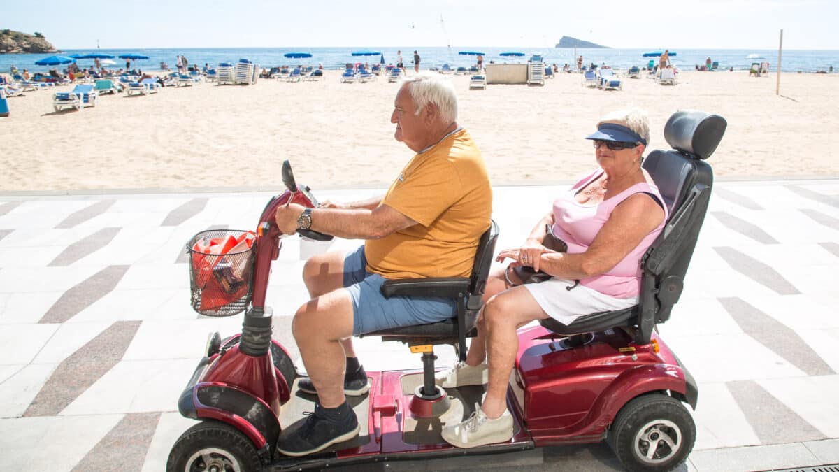 Una pareja pasea en moto eléctrica por el paseo de la playa de Poniente, a 11 de marzo de 2023, en Benidorm, Alicante, Comunidad Valenciana (España).