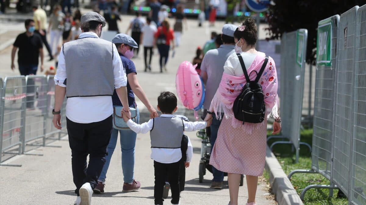 Una pareja pasea de la mano de un niño, vestidos de chulapos, durante las celebraciones de San Isidro en Madrid.