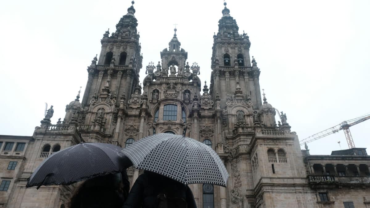 Una pareja observa la catedral de Santiago sin andamios después de varios años de obra
