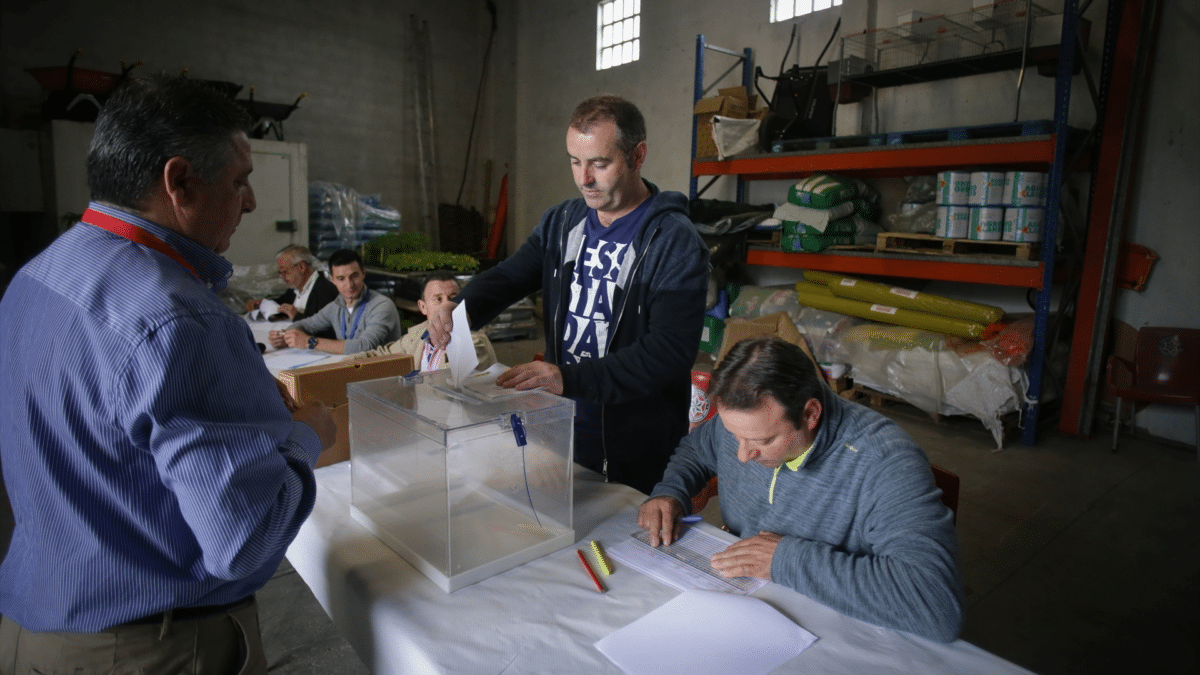 Varias personas ejercen su derecho a voto mientras se preguntan ¿qué pasa si no les localizan para una mesa electoral?