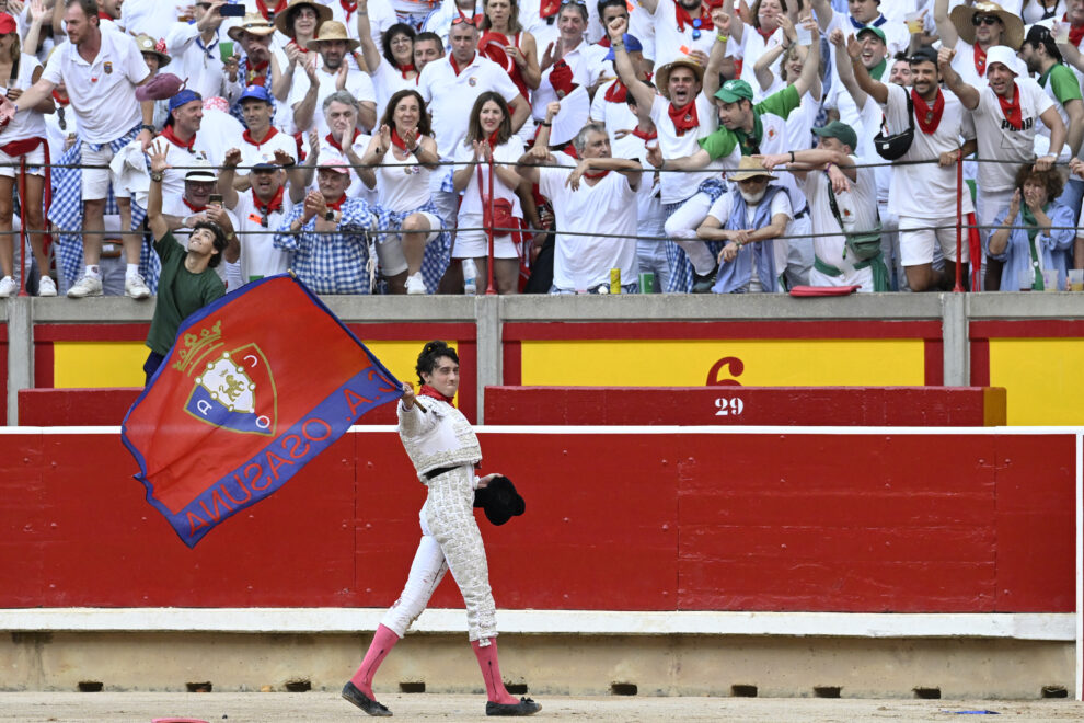 Roca Rey ondea la bandera de Osasuna en su vuelta al ruedo en Pamplona.