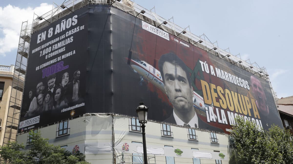 Una gran lona de la empresa Desokupa cubre un edificio en la calle Atocha de Madrid