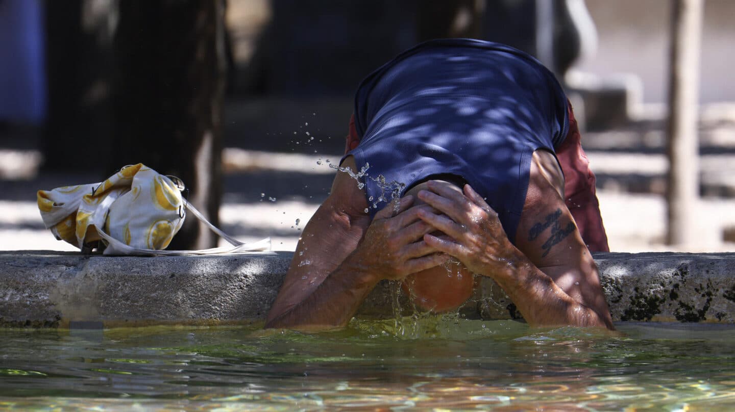 Un turista se refresca en la Fuente de los Naranjos de la mezquita-catedral de Córdoba