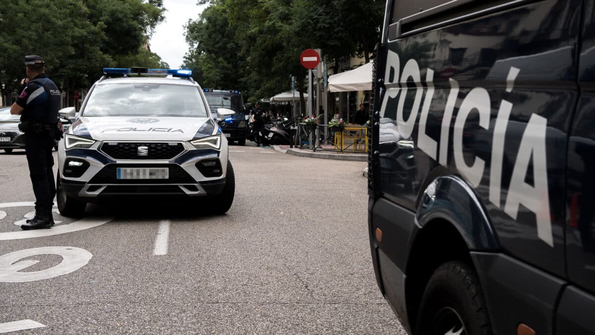 Un coche de Policía Nacional frente a una concentración de funcionarios de justicia