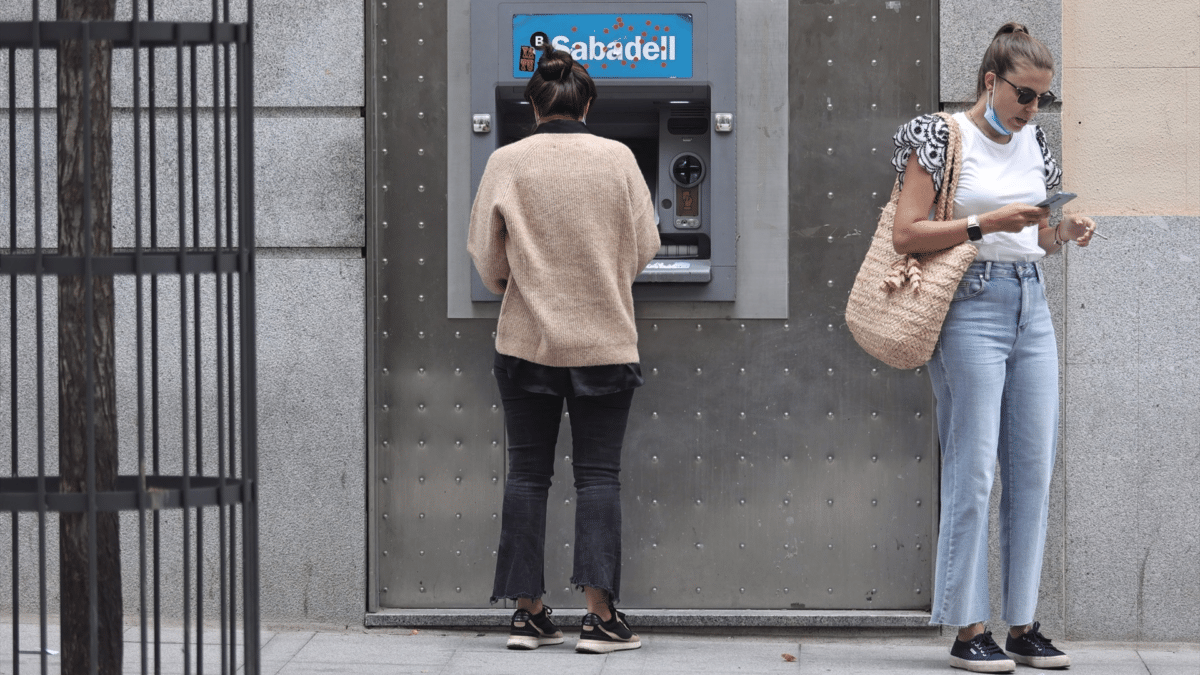 Una mujer en el cajero de Banco Sabadell al saber cuándo se cobra la pensión en julio de 2023