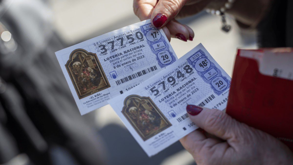 Una mujer sostiene dos décimos para el sorteo extraordinario de la Lotería de Navidad, que empieza a venderse este 3 de julio de 2023