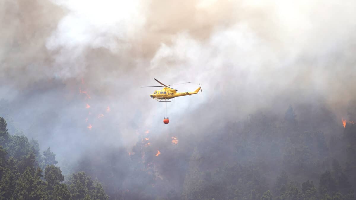 Un helicóptero contra incendios descarga agua sobre un incendio forestal en Tenerife Norte