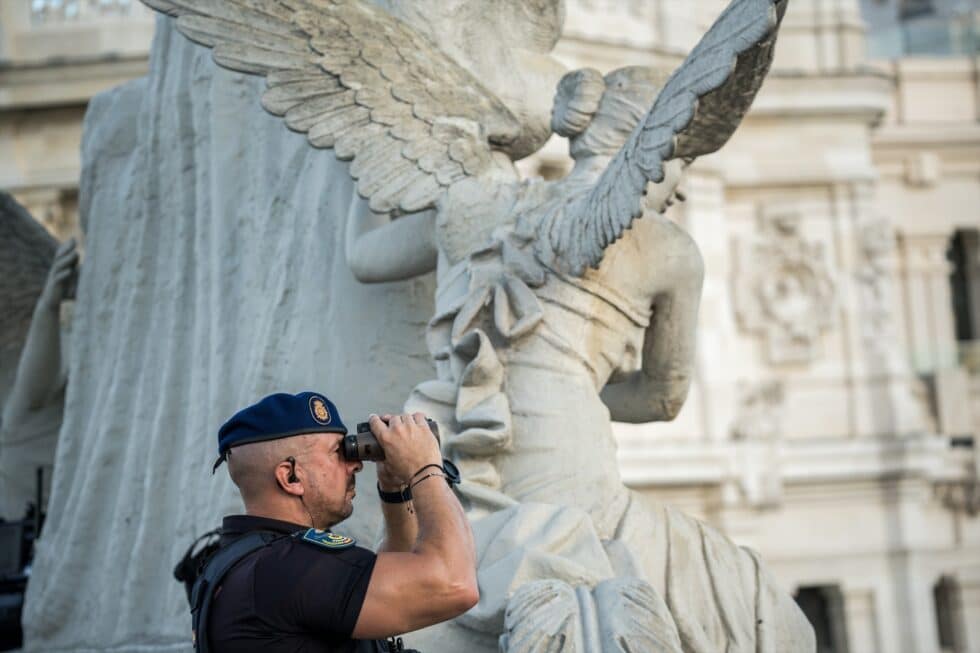 Un agente de Policía Nacional vigila con prismáticos la manifestación del Orgullo 2023. Diego Radamés / Europa Press