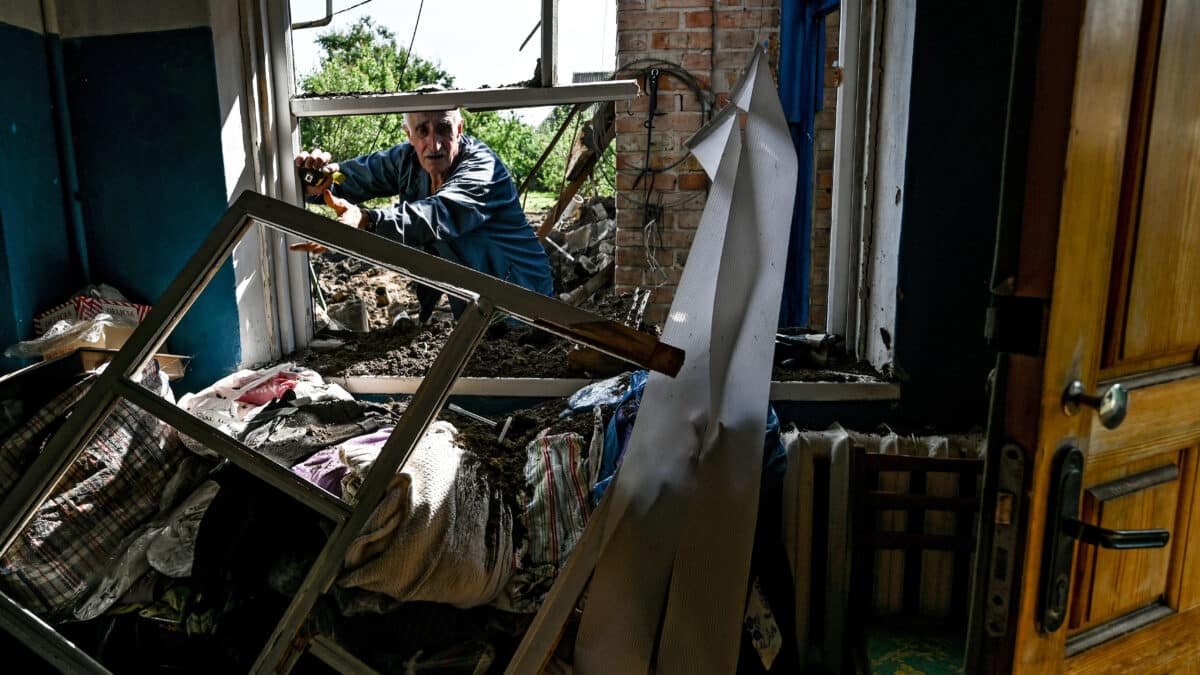 Un hombre inspecciona el daño en su vivienda por un misil ruso en Kushuhum (Ucrania).