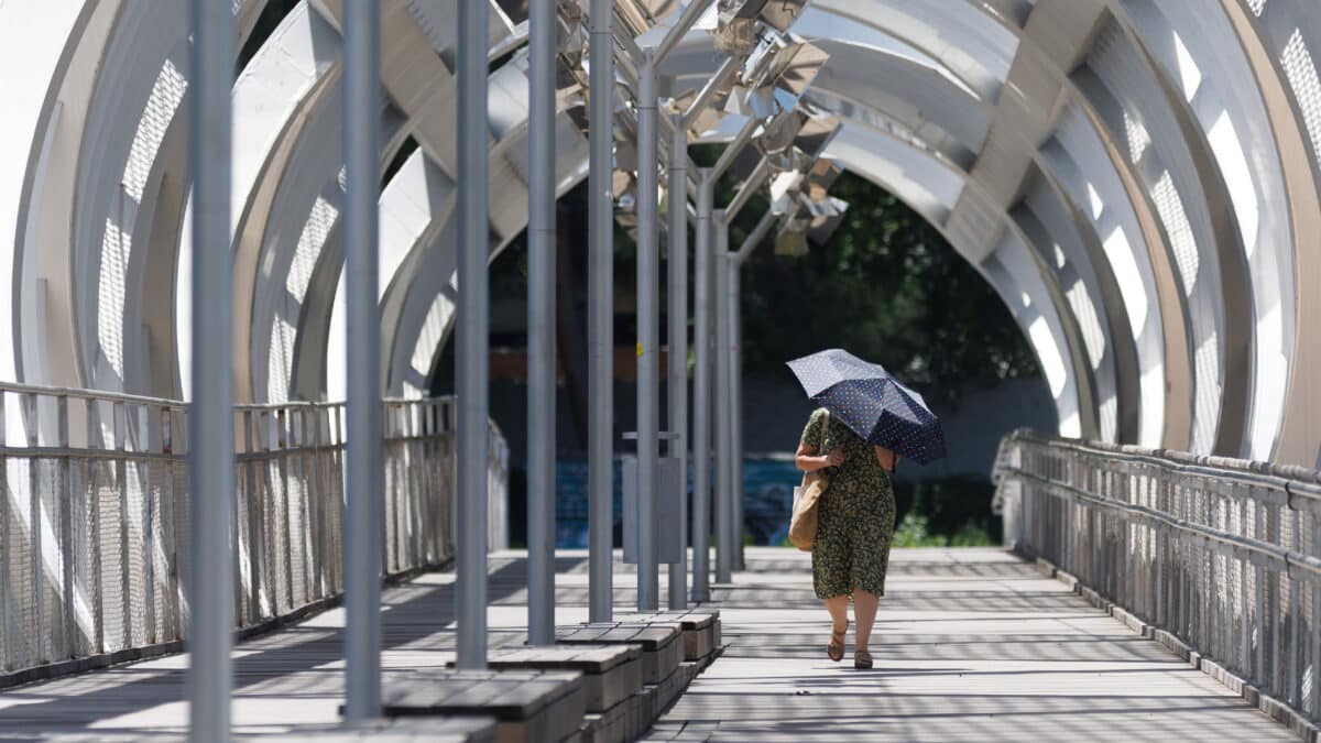 Una mujer se cubre del sol en Madrid Río.