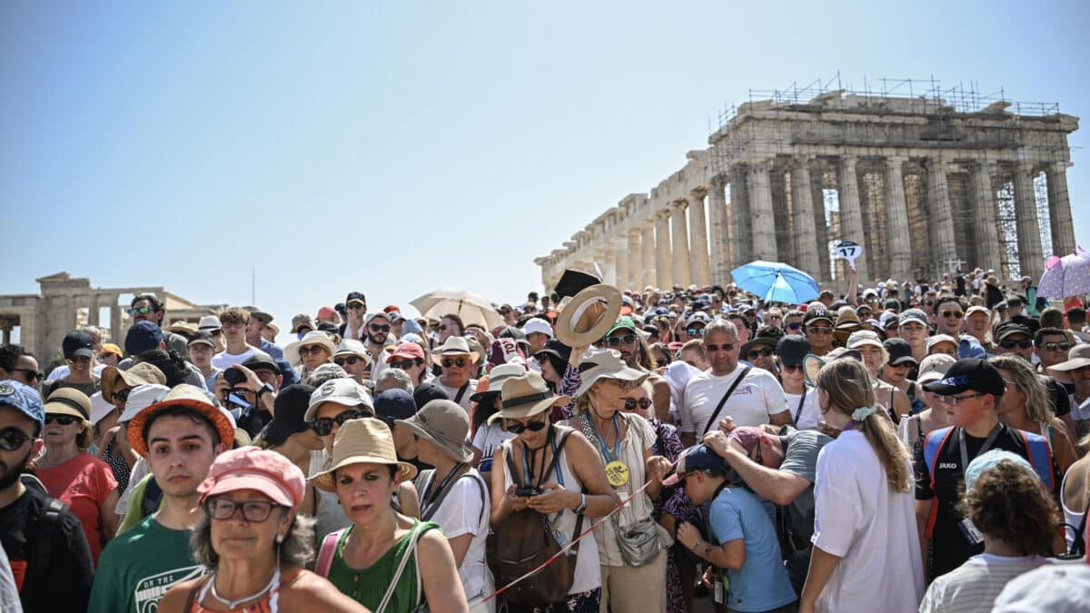 Una gran multitud de turistas visitan el Templo del Partenón en la colina de la Acrópolis durante una ola de calor.