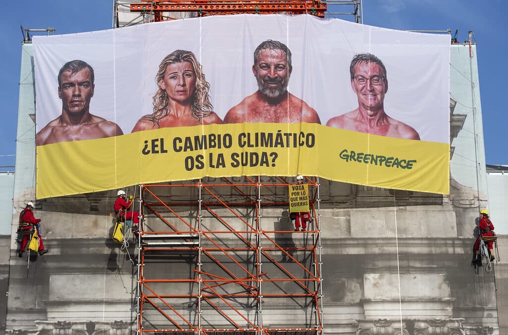 Greenpeace despliega una pancarta en la Puerta de Alcalá contra los principales candidatos: "¿El cambio climático os la suda?"