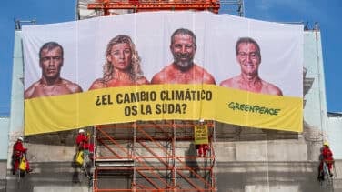 Greenpeace despliega una pancarta en la Puerta de Alcalá contra los principales candidatos: "¿El cambio climático os la suda?"